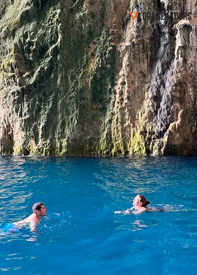 a couple, swimming inside Haxhi Ali Cave, in Vlore