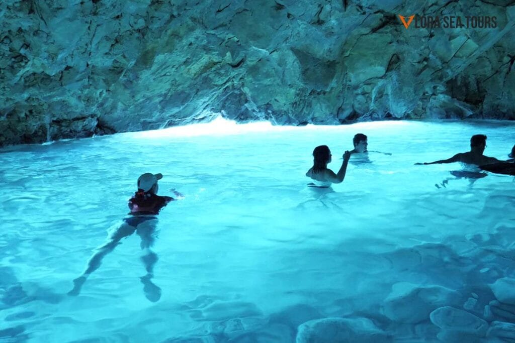 People swimming inside the Blue Cave, in Karaburun peninsula, Vlore Albania